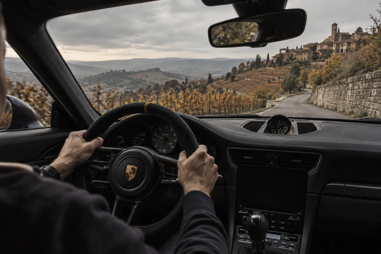 View from inside a Porsche on a road in the Langhe; illustrative visual